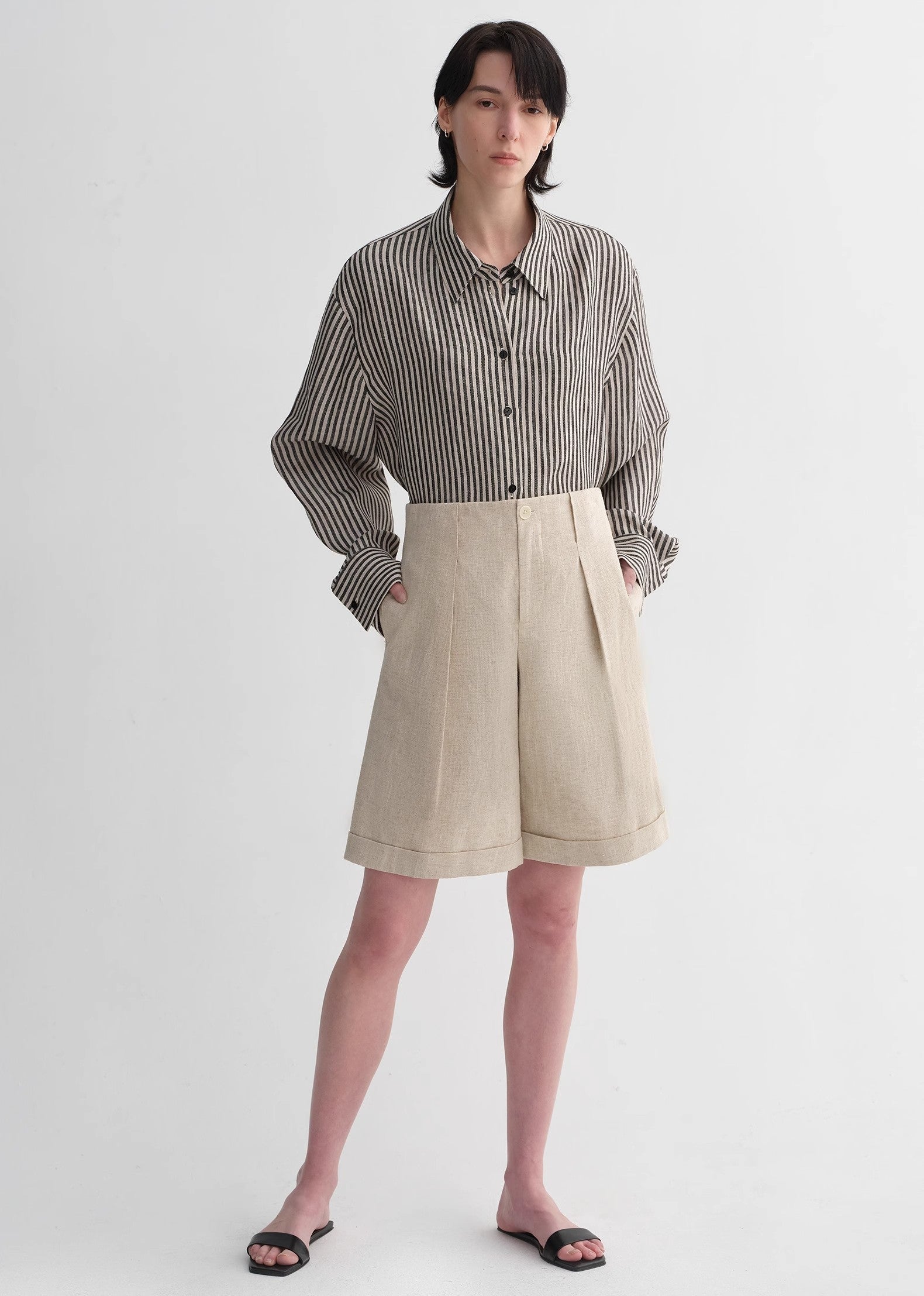 Sophisticated linen waistless pleated wide-leg cropped pants for women, featuring architectural silhouette, textured side pockets