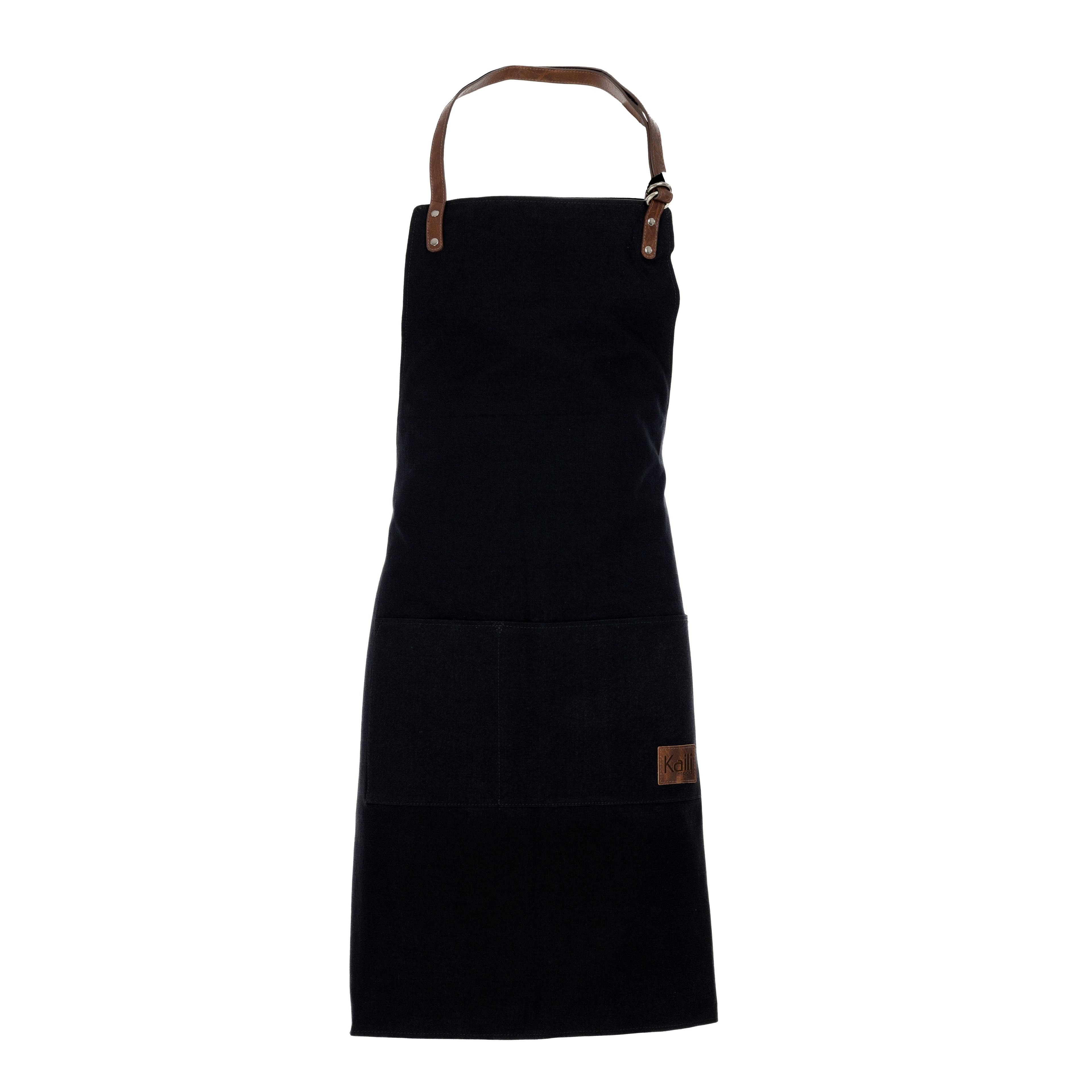 K0015AB | Canvas/ Genuine full-grain leather, ruffled Work Apron. Black/Brown head color. Nickel Antique Accessories. Dimensions: 70 x 90 x 0.5 cm. Packaging: Polybag